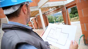 Construction manager checking blueprint on site